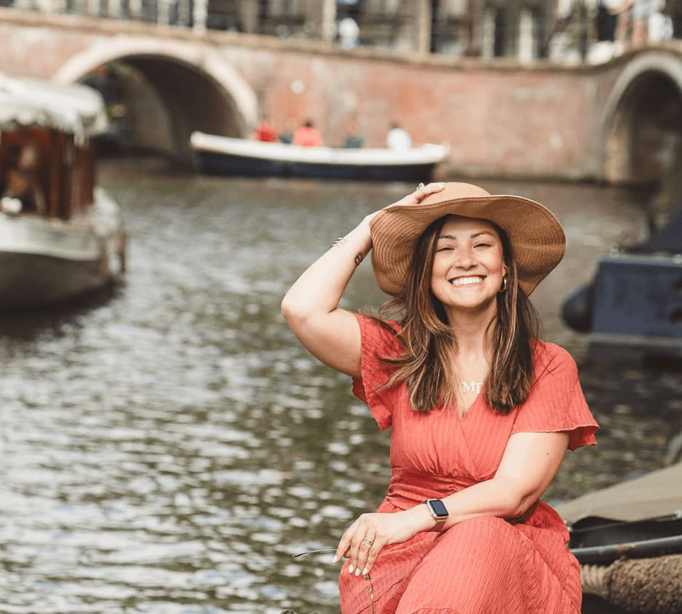 Mulher em barco nos canais de Amsterdam - vantagens de morar na Europa