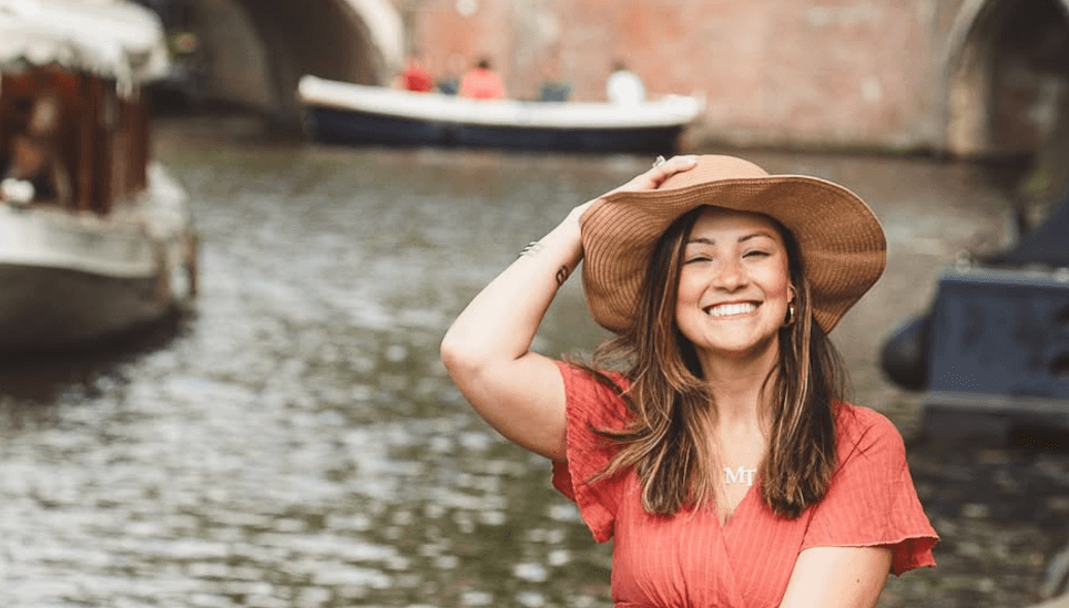 Mulher em barco nos canais de Amsterdam - vantagens de morar na Europa