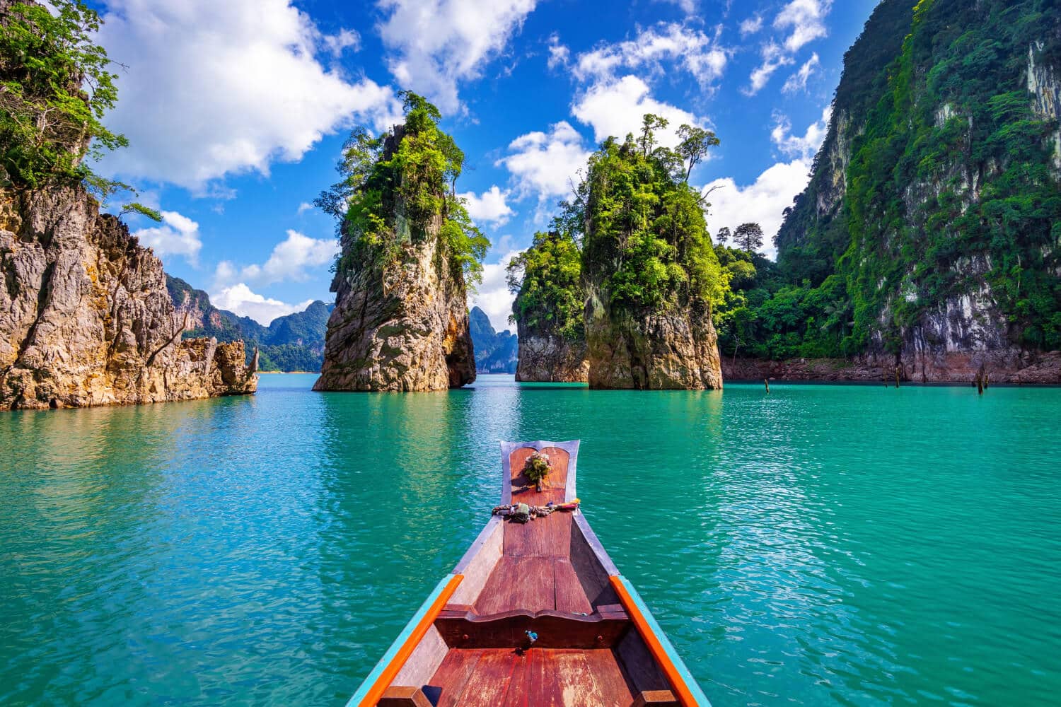 Barco no mar entre montanhas em um dos países mais baratos para morar: Tailândia